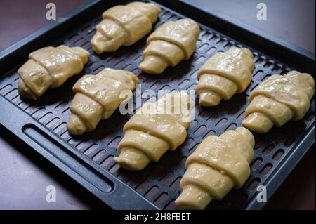 Croissants faits maison.La pâte à croissant est disposée dans un four pour la mettre dans le four Banque D'Images