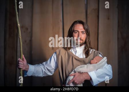 Caractère biblique de Joseph tenant Jésus bébé dans un berceau Banque D'Images