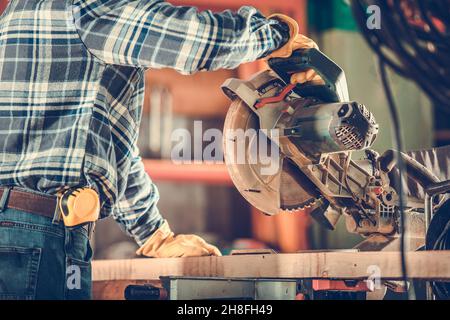 Travailleur du bois utilisant une puissante scie circulaire gros plan photo.Thème de l'industrie de la construction. Banque D'Images