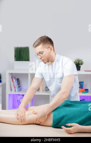 Thérapeute ostéopathie travaillant massage sportif avec les jambes de la femme athlète. Banque D'Images