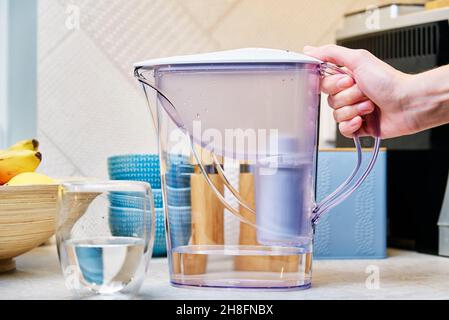 Femme prendre le filtre à eau pour verser un verre d'eau Banque D'Images