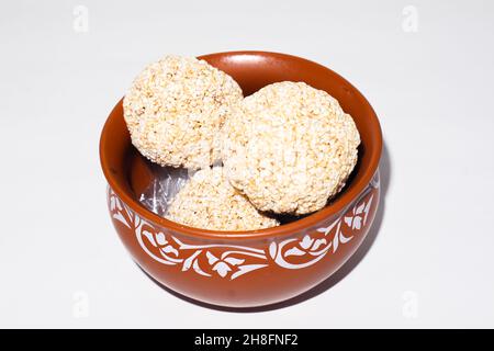 Doux indien pour le festival traditionnel makar sankranti :Rajgira laddu fait de graines d'Amaranth en bol sur fond blanc Banque D'Images