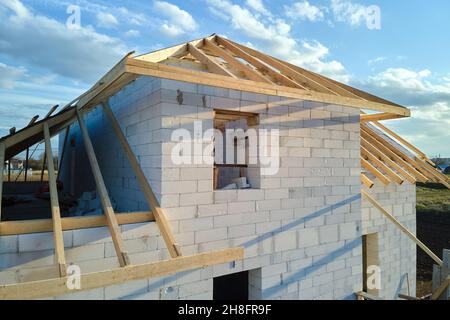 Vue aérienne du cadre inachevé de la maison privée avec murs en béton léger aéré et cadre de toit en bois en construction. Banque D'Images