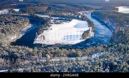 Rivière d'hiver et forêt enneigée.Vue aérienne de la nature hivernale.Rivière et forêt gelées en hiver. Banque D'Images