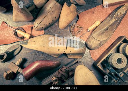 Atelier de cordonnier antique avec outils, sangle, cuir et règles.Atelier de cordonnerie antique Banque D'Images