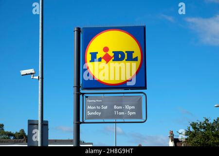 Vue extérieure du supermarché Lidl enseigne logo et heures d'ouverture ciel bleu à Cardiff pays de Galles Royaume-Uni Grande-Bretagne KATHY DEWITT Banque D'Images