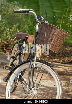 Ammaco « Hollande » femmes vélo de style hollandais dans un joli cadre de jardin, avec panier devant le guidon. Banque D'Images