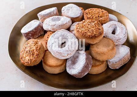 Spécialités de vacances polvorones et mantecados en assiette dorée sur table en pierre beige, vue de dessus Banque D'Images