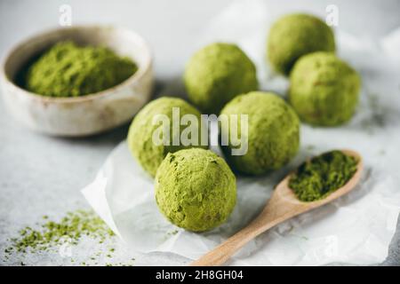 Boules d'énergie de matcha de thé vert sur papier parchemin, vue rapprochée.Truffes végétaliennes saines Banque D'Images