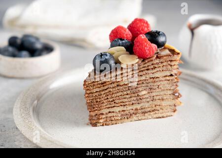 Tranche de gâteau de crêpe au chocolat avec baies sur une assiette Banque D'Images