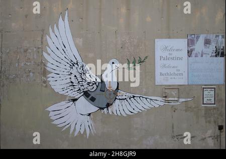 Banksy grafitti d'une colombe en armure de corps sur un mur de bâtiment. Banque D'Images