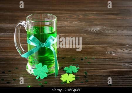 La journée de St Patricks est agrémentée d'une pinte de bière verte sur une table en bois avec des shamrocs en feutre faits à la main. Espace-copie Banque D'Images