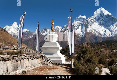 Stupa blanc, drapeaux de prière, mur omanais avec symboles de prière bouddhiste - monts Kangtega, Thamserku et Ama Dablam, chemin vers le camp de base de l'Everest, vallée de Khumbu Banque D'Images