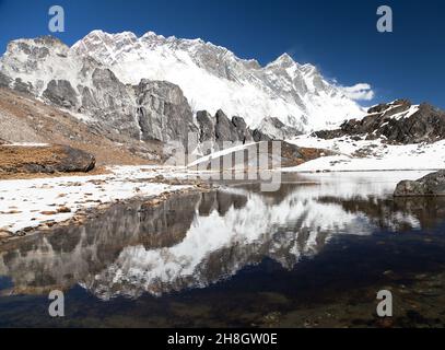 Vue panoramique sur Lhotse et Nuptse face sud de la roche et Makalu miroir dans le petit lac sur le chemin de l'Everest Camp de base - Parc national de Sagarmatha - ne Banque D'Images