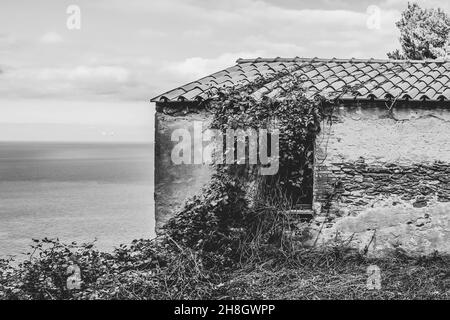 Vue en noir et blanc d'un vieux bâtiment abandonné en ruines sur l'île de Gorgona, Livourne, Italie Banque D'Images