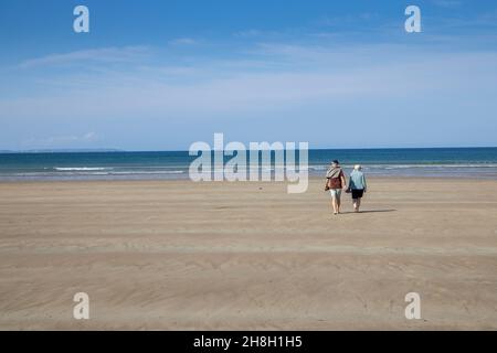 Couple marchant sur la plage à Newgale, Pembrokeshire, pays de Galles, Royaume-Uni Banque D'Images