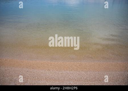 Ondulations sur la surface du fond de mer de sable, eau de mer bleue claire et calme, poissons dans l'eau, texture de la nature Banque D'Images