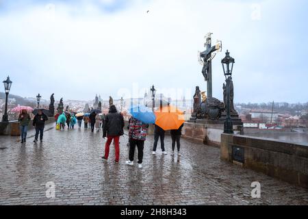 Prague - 11 mars 2020 : les gens traversent le pont Charles par temps de pluie Banque D'Images