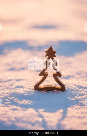 Décoration de Noël en bois dans la neige au coucher du soleil.Fond de carte de vœux d'hiver Banque D'Images