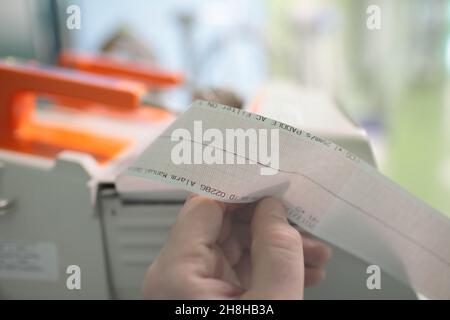 Médecin tenant dans les mains le dossier ECG avec le cœur à l'arrêt. Banque D'Images