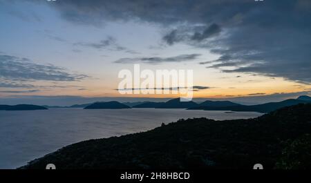 Coucher de soleil coloré sur l'autoroute Adriatique en Croatie avec vue sur la côte et silhouettes des îles au loin Banque D'Images