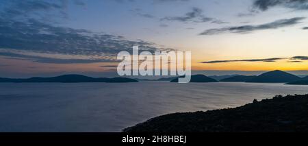 Coucher de soleil coloré sur l'autoroute Adriatique en Croatie avec vue sur la côte et silhouettes des îles au loin Banque D'Images