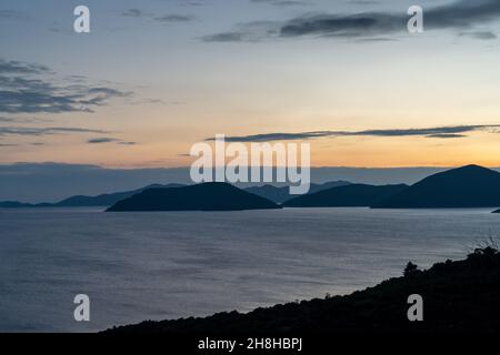 Coucher de soleil coloré sur l'autoroute Adriatique en Croatie avec vue sur la côte et silhouettes des îles au loin Banque D'Images