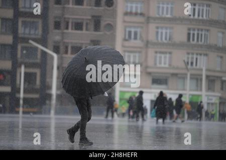 (211130) -- ISTANBUL, 30 novembre 2021 (Xinhua) -- Une personne tenant un parapluie marche en pluie sur la place Taksim à Istanbul, Turquie, 30 novembre 2021.De fortes tempêtes de vent ont tué au moins six personnes et en ont blessé plus de 50 autres dans la région nord-ouest de la Turquie depuis lundi, selon les médias locaux.(Xinhua/Sadat) Banque D'Images