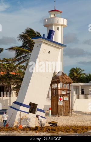 Mexique, Quintana Roo, Puerto Morelos, femmes collectant l'algue Sargassum près du phare incliné, le résultat du réchauffement climatique Banque D'Images