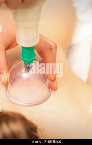 Femme recevant un traitement par immersion sous vide sur le dos couché sur la poitrine dans le salon de massage Banque D'Images