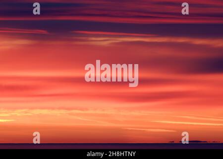 Lever de soleil à l'est depuis Mumbles Head, au-dessus de la mer jusqu'à l'horizon lointain et les nuages colorés rouge et orange par le soleil tôt le matin. Banque D'Images
