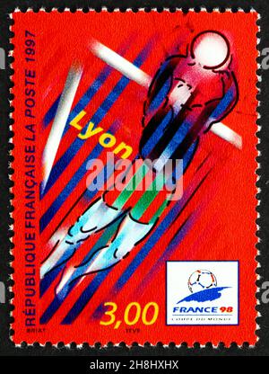 FRANCE - VERS 1997 : un timbre imprimé en France montre Lyon, ville hôte des Championnats du monde de football 1998, scène d'action stylisée, vers 1997 Banque D'Images