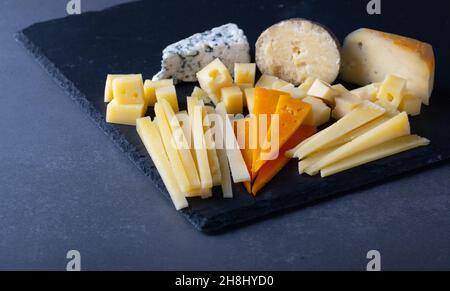 Différents types de fromage sur un plateau en pierre Banque D'Images