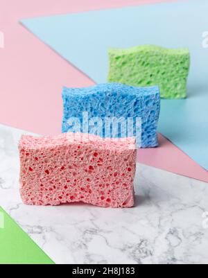 Disposition créative avec éponges pour le lavage de la vaisselle sur fond multicolore Banque D'Images