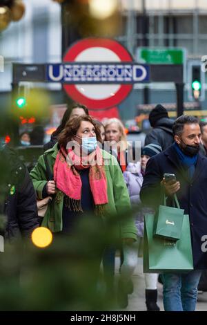 Londres, Royaume-Uni.30 novembre 2021.Les gens passent des arbres de Noël devant Harvey Nichols à Knightsbridge le premier jour où des revêtements de visage sont de nouveau nécessaires dans les magasins, suite aux nouvelles mesures du gouvernement britannique pour tenter de freiner la propagation du coronavirus suite à la détection de la variante Omicron.Credit: Stephen Chung / Alamy Live News Banque D'Images