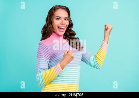 Photo de brunette étonne les mains de jeune femme les poings portent un chandail violet isolé sur fond de couleur sarcelle Banque D'Images