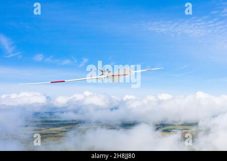 Un drone militaire vole dans les nuages à la surface de la terre Banque D'Images