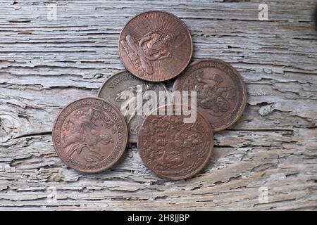 Pièces de cuivre indiennes anciennes sur fond de bois Banque D'Images