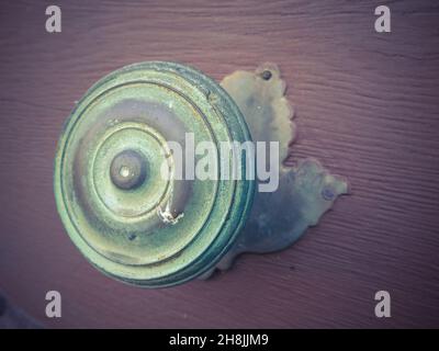 Gros plan sur un vieux bouton de porte rond vert vieilli Banque D'Images