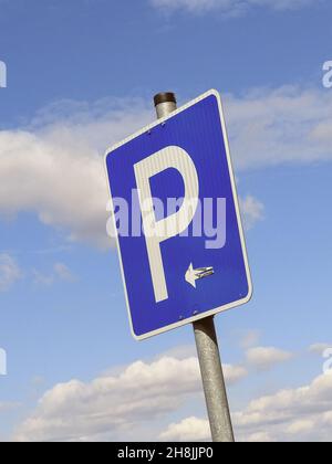 Plan vertical d'un panneau de stationnement sur un poteau contre un ciel bleu nuageux Banque D'Images