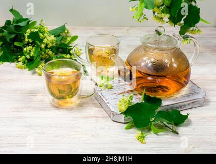 Théière et deux tasses de thé avec un tilleul sur une table en bois. Thé de guérison. Banque D'Images