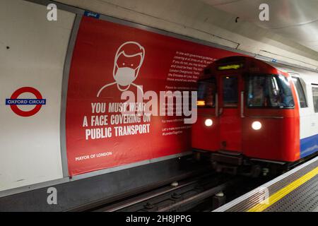 Londres, Royaume-Uni.30 novembre 2021.Un grand panneau publicitaire indique aux passagers que les revêtements de visage sont maintenant de nouveau obligatoires pour voyager dans les transports publics après que le gouvernement britannique a annoncé de nouvelles mesures pour freiner la propagation du coronavirus en réponse aux cas de détection de la nouvelle variante Omicron dans le pays.Credit: Stephen Chung / Alamy Live News Banque D'Images