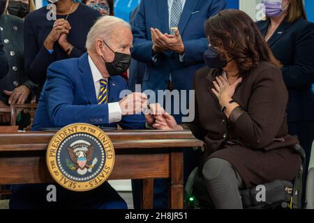 Le président des États-Unis Joe Biden mains le stylo qu'il a utilisé au sénateur américain Tammy Duckworth (démocrate de l'Illinois), après avoir signé l'article 796 : protéger les mères qui ont servi la loi de 2021, dans l'Auditorium de la Cour du Sud de l'immeuble Eisenhower du Bureau exécutif de la Maison Blanche à Washington, le 30 novembre 2021.Les lois Biden signées sont S. 796, «protéger les mères qui ont servi la loi de 2021, S. 894, «embaucher des vétérans Heroes Loi de 2021, S. 1031,« Un projet de loi pour obliger le contrôleur général des États-Unis à mener une étude sur les disparités liées à la race et à l'origine ethnique à l'égard de certains avantages Banque D'Images