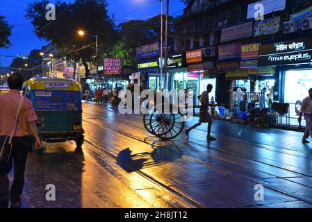 Les tireurs de pousse-pousse de Kolkata.La métropole dense est l'un des seuls endroits en Inde — et l'un des rares au monde — où des flottes de rickshaws tracées à la main sillonnent encore les rues.Kolkata, Inde. Banque D'Images