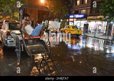 Les tireurs de pousse-pousse de Kolkata.La métropole dense est l'un des seuls endroits en Inde — et l'un des rares au monde — où des flottes de rickshaws tracées à la main sillonnent encore les rues.Kolkata, Inde. Banque D'Images