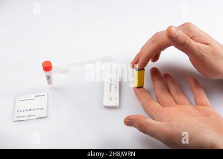 injection isolée d'une main avec un lancet prenant un échantillon de sang du doigt et un blanc rapide express antigène antobody coronavirus covid-19 pandémie t Banque D'Images
