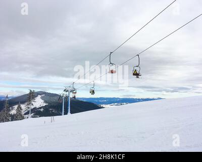 Station de ski, personnes en télésiège, vue sur la montagne de neige à backgroun, montagnes Carpathin, Dragobrat, Ukraine Banque D'Images