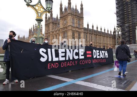 Londres, Royaume-Uni.30 novembre 2021.Les manifestants tiennent une bannière disant « Silence = Death slogan » aux chambres du Parlement du pont de Westminster pendant la manifestation.les militants exigent que le gouvernement britannique suspende les règles de propriété intellectuelle qui bloquent la production de vaccins dans le monde entier.(Photo de Thomas Krych/SOPA Images/Sipa USA) crédit: SIPA USA/Alay Live News Banque D'Images