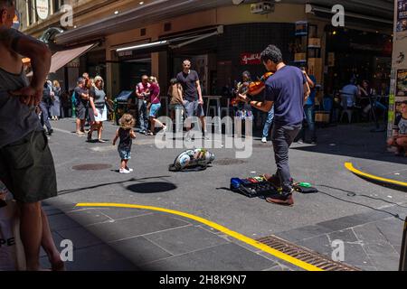 MELBOUR, AUSTRALIE - 16 novembre 2019 : un musicien de rue qui fait de la musique en public avec des gens qui regardent, la vie de la ville de Melbourne avant la pandémie, Australie Banque D'Images