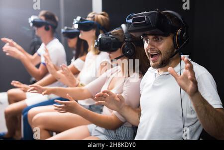 Un homme excité qui vit avec ses amis la réalité virtuelle Banque D'Images